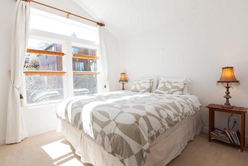 a white bedroom with a bed and a window at Venturi 30 Day in Hood River