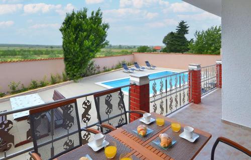 a balcony with a table and chairs and a swimming pool at Amazing Home In Polaca in Pertenjača
