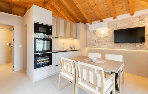een keuken met een houten tafel met stoelen en een fornuis bij Lovely Home In Prigradica in Prigradica