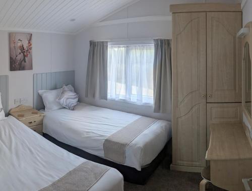 Maltby le MarshにあるWren Lodgeのベッド2台と窓のある寝室