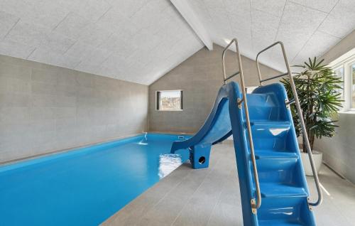 an indoor pool with a blue slide in a room at Amazing Home In Glesborg With Sauna in Fjellerup