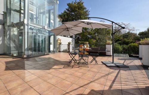 a patio with a table and an umbrella in front of a building at Le Stanze Letterarie in Cibali
