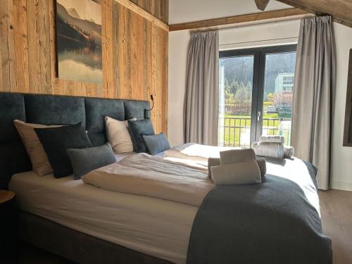 a large bed in a bedroom with a large window at Chalet am See! in Afritz