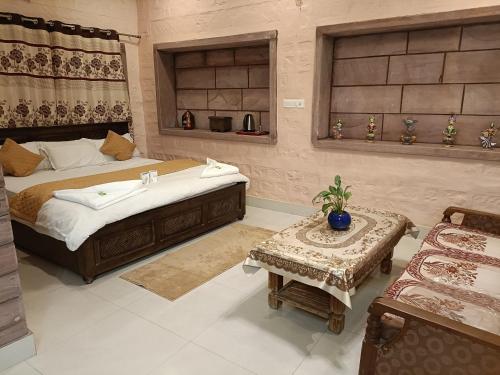 a bedroom with a bed and a table and a couch at Gopal Home Stay & Guest House in Jodhpur
