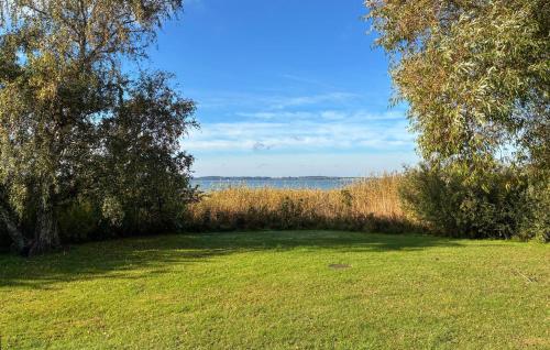 a field with trees and grass and the water at 2 Bedroom Stunning Home In Helsinge in Karsemose