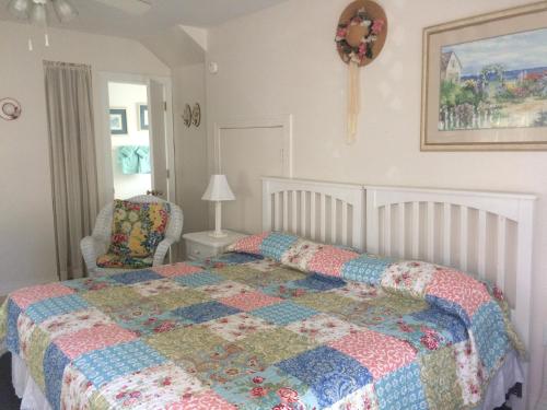 a bedroom with a bed with a quilt on it at Angie's Guest Cottage in Virginia Beach