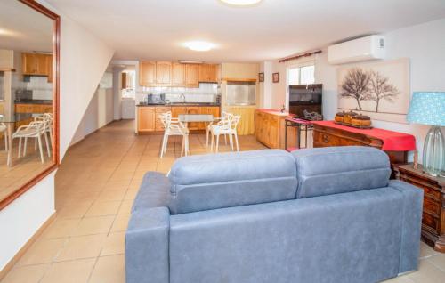 a living room with a blue couch and a kitchen at Beautiful Apartment In Oliva With Wifi in Playa Oliva Nova