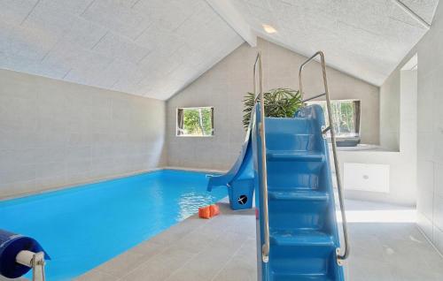 a swimming pool with a blue slide in a house at Cozy Home In Glesborg With Sauna in Fjellerup