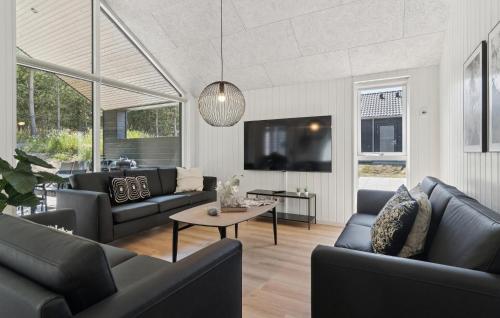 a living room with couches and a table at Cozy Home In Glesborg With Sauna in Fjellerup