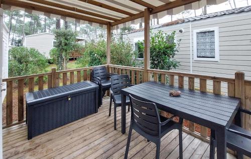 patio ze stołem i krzesłami na pokładzie w obiekcie Stunning Stacaravan In Saint-Julien-En Born w mieście Saint-Julien-en-Born