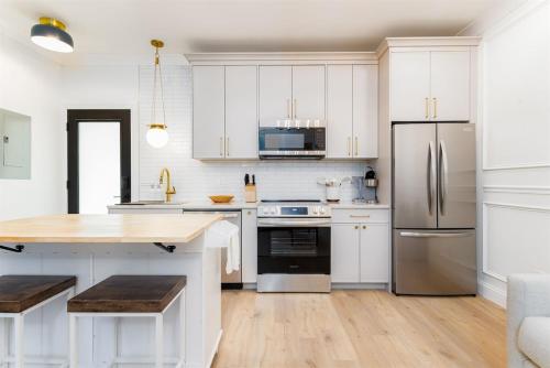 une cuisine avec des armoires blanches et un réfrigérateur en acier inoxydable dans l'établissement The Darby Condo - Cozy 1Br Condo - Close to ND campus, à South Bend