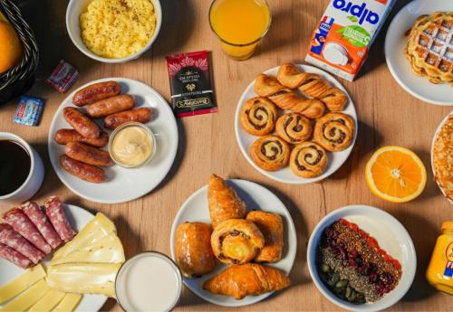 Una mesa cubierta con platos de comida y bebidas. en B&B HOTEL Lille Centre Grand Palais, en Lille