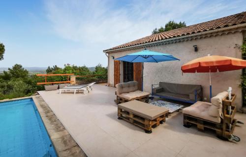 a patio with chairs and an umbrella and a pool at La Champêtre in Fayence
