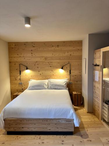 NavenzeにあるLocanda Valmorelの木製の壁と大きなベッドのある寝室