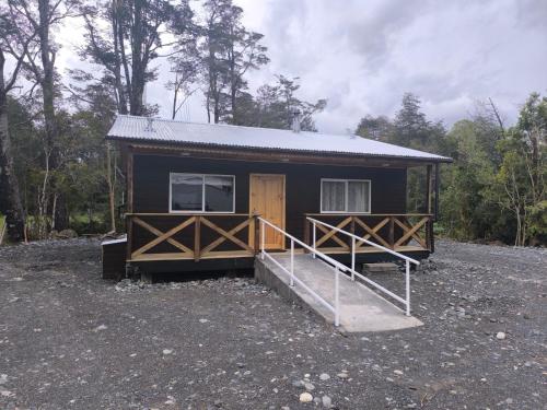 a small cabin with a porch and a door at Cabaña La Casona in Chaitén