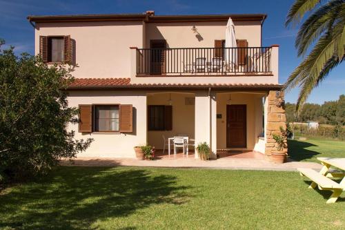 ein Haus mit einem Balkon und einem Tisch in der Unterkunft Residence with swimming pool a few minutes from Alghero in Alghero