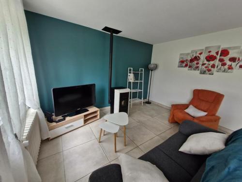 un salon avec un canapé et une télévision dans l'établissement Cosy la Riveraine Cottage, à Saint-Aignan