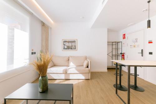 una sala de estar con un sofá y una mesa en Guastavino by Alma Suites, en Valencia