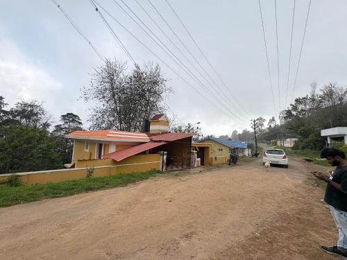 科代卡纳尔G k Holiday的一个男人站在房子旁边的土路上。