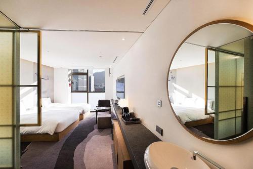 a bathroom with a mirror and a bed and a sink at Stayrak Hotel in Seoul