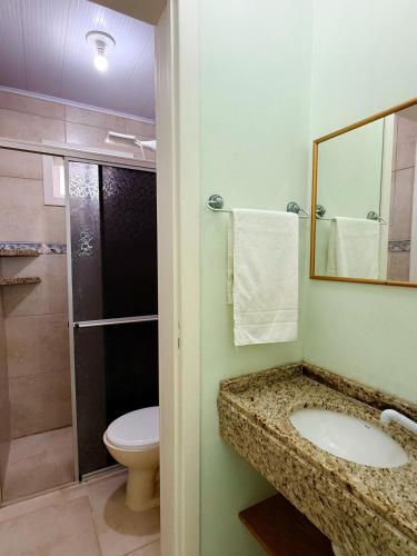 a bathroom with a sink and a toilet and a shower at Pousada Lagoa dos Ventos in Barra de Ibiraquera