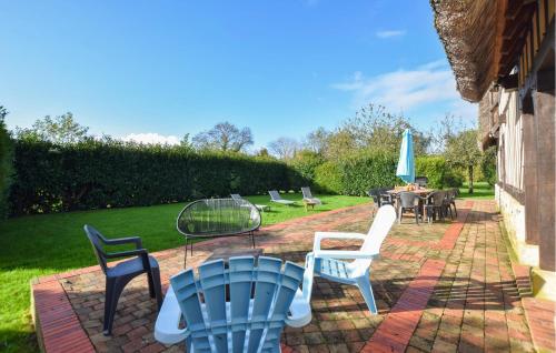eine Terrasse mit Stühlen, einem Tisch und einem Sonnenschirm in der Unterkunft Confortable Maison Normande in Saint-Léger-sur-Bonneville
