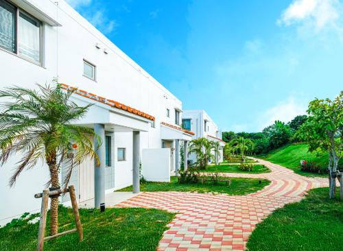 a house with a brick walkway next to a building at Seaside Village 13(シーサイドヴィレッジ・サーティーン) in Ishigaki Island