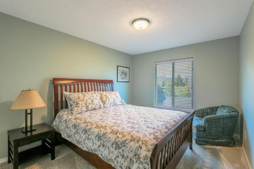 a bedroom with a bed and a lamp and a window at Quail On Sunset in Hood River