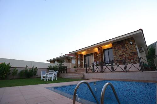 a house with a swimming pool in front of it at Sariska Bliss Farm, #2-BHK, #Private Pool & Garden in Alwar