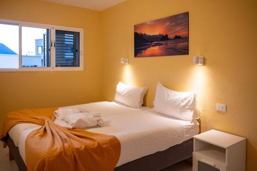 a bedroom with a bed with white sheets and a window at Apartamento con vistas al mar en el Médano in El Médano