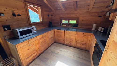 una cocina en una cabaña de madera con microondas en Sadzot, en Grimentz