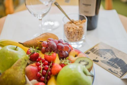 a plate of fruit on a table with a wine glass at Central-Hotel Kaiserhof in Hannover