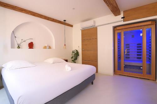 a bedroom with a white bed and a window at Sublime, hyper-centre d'Ajaccio, avec Spa, Sauna, Vue mer & Plage à 3min in Ajaccio
