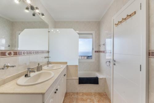 een badkamer met twee wastafels, een bad en een douche bij Ocean View Costa Adeje in Adeje