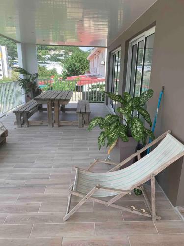 a hammock sitting on the porch of a house at Appartement spacieux avec vue sur la mer à Le Marin in Le Marin