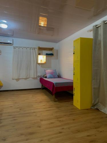 a room with a bed and a yellow cabinet at Kura Ora Guest House in Rangiroa