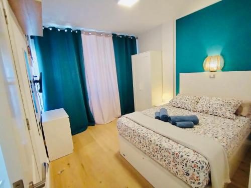 a bedroom with a bed with a blue teddy bear on it at Sunset Ocean Playa del Ingles in Playa del Ingles