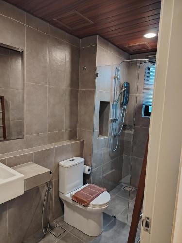 a bathroom with a toilet and a shower at Timurbay Seafront By Moonlight pool view in Kuantan