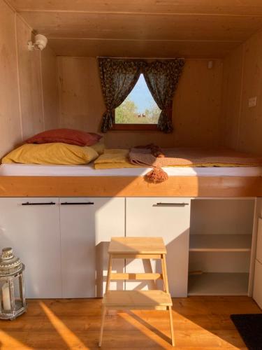 a tiny house with a bed and a ladder at Off-grid maringotka Cibéba in Rača