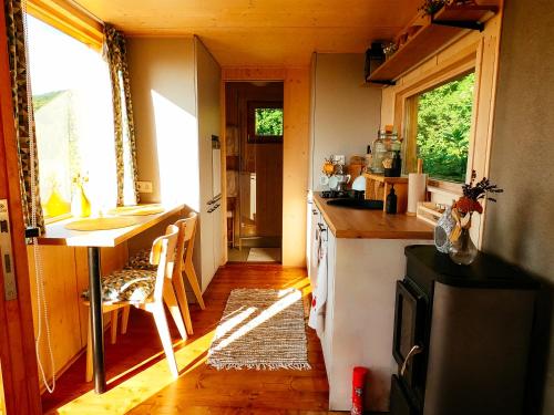 a kitchen with a counter and a table in a house at Off-grid maringotka Cibéba in Rača