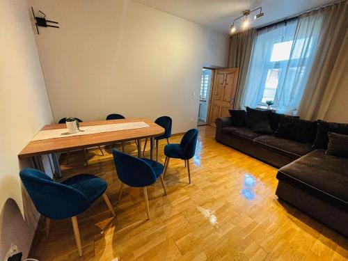 a living room with a table and chairs and a couch at Apartament R48 in Dąbrowa Tarnowska