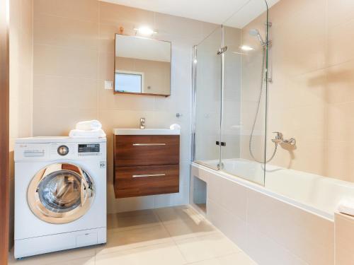 a bathroom with a washing machine and a bath tub at Penthouse Studio with Terrace and City View - 5 mins walk to Hauptbahnhof Train Station in Vienna