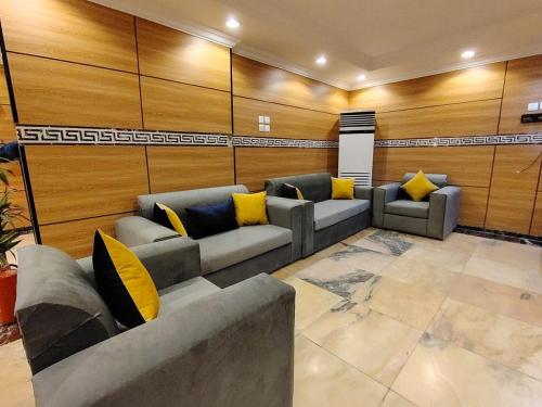 a living room with couches and yellow pillows at فندق فجر الرسالة in Al ‘Azīzīyah