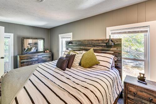 a bedroom with a large bed with a wooden headboard at 6 Mi to Notre Dame Family Retreat with Deck and Yard in Mishawaka