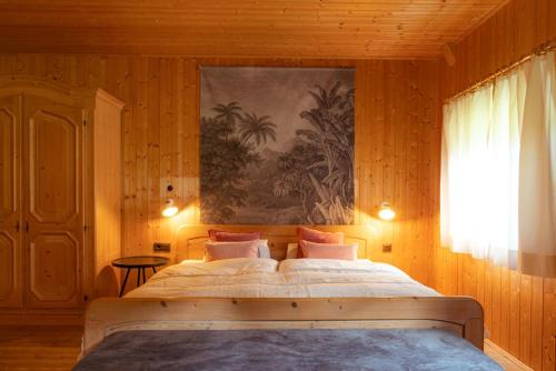 a bedroom with a large bed with a painting on the wall at Bauernhaus Spathen in Santa Valburga St. Walburg