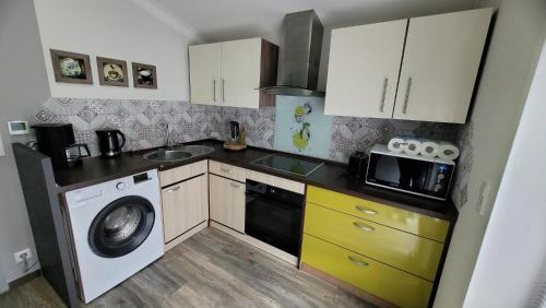 a small kitchen with a washing machine and a washer at Ferienwohnung Nordstern in Papenburg
