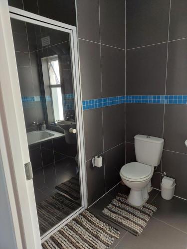 a bathroom with a toilet and a sink and a shower at Chelmsford close in Oakdale
