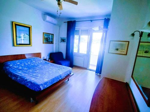 a bedroom with a bed with a blue comforter at La Villetta di Odisseo in Terracina
