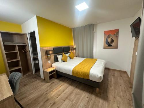 ブリュマトにあるHôtel NOROTELの黄色い壁のベッドが備わるホテルルームです。
