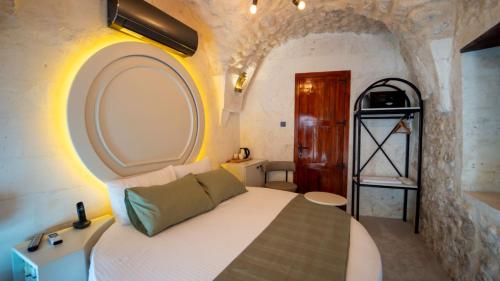 a bedroom with a white bed and a bathroom at Hotel Estara in Urfa